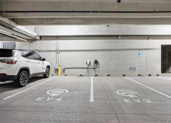 A white car is parked in a parking space with the label EV4.