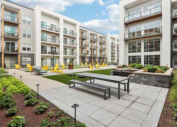 A courtyard with a bench and a table surrounded by buildings.