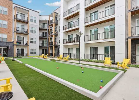 A miniature golf course is located in the courtyard of a residential building.