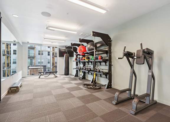 A gym with a variety of equipment including treadmills, weights, and exercise machines.