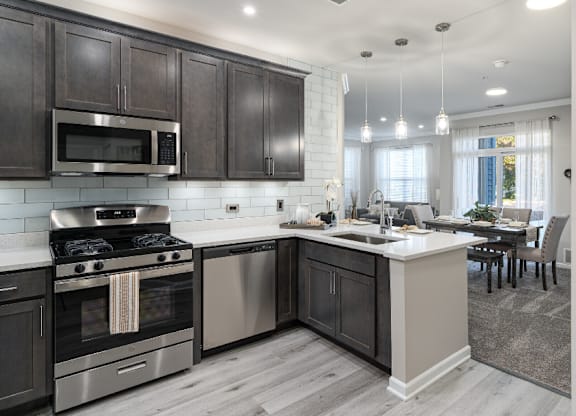 a kitchen with stainless steel appliances and a large island with a sink at Bristol Station, Naperville, IL