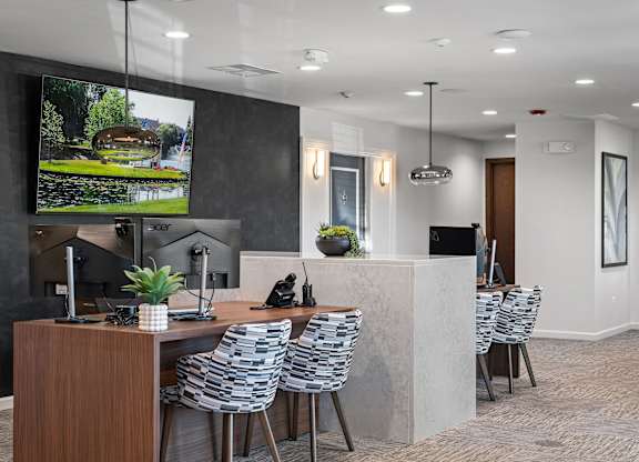 A modern office space with a large screen TV mounted on the wall.