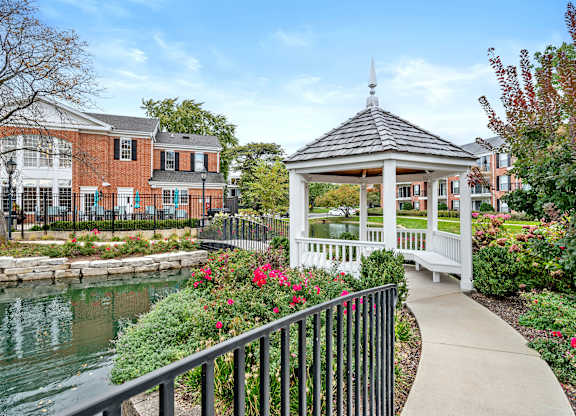 A gazebo is surrounded by flowers and a walkway.