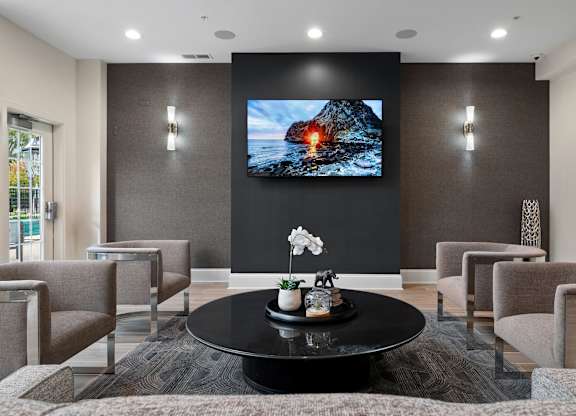 A modern living room with a flat screen TV mounted on the wall.