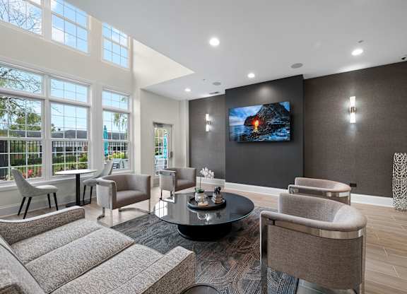 A modern living room with a large screen TV and comfortable seating.