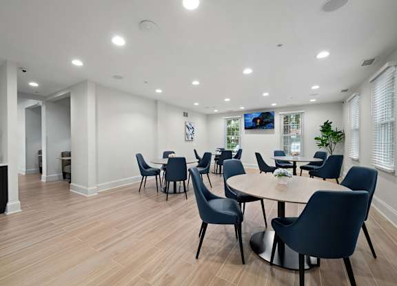 A modern dining room with a round table and chairs.