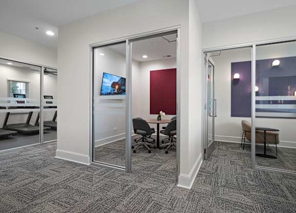 A conference room with a grey carpet and a red wall.