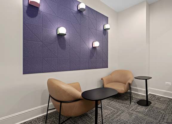 A purple wall with lights and a tan chair.