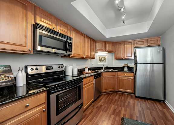 A kitchen with wooden cabinets and black appliances.