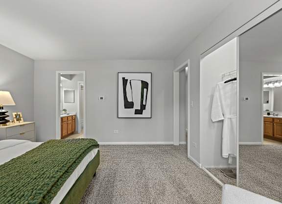 A bedroom with a green bedspread and a large painting on the wall.