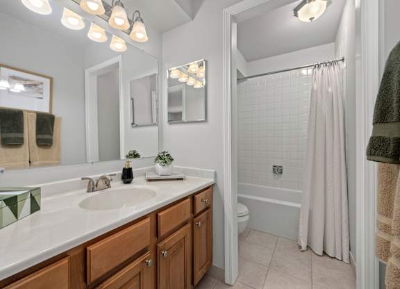 A bathroom with a white sink and a white tub.