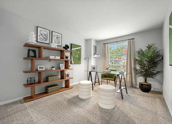 A room with a carpeted floor, a wooden shelf, a green chair, a white ottoman, and a potted plant.