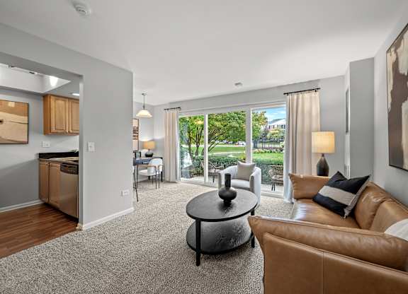 A living room with a brown leather couch and a grey coffee table.
