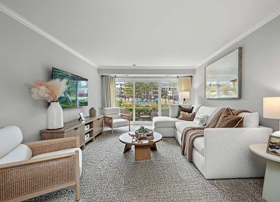 A well-lit, spacious living room with a variety of seating options and a coffee table.