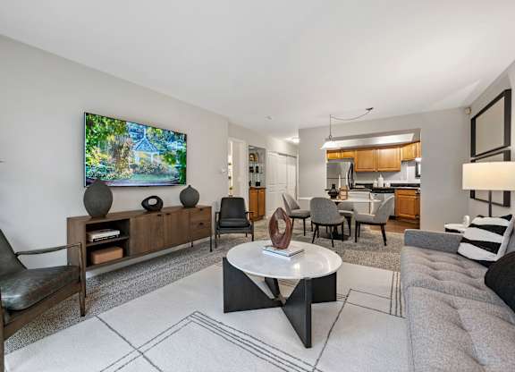 A modern living room with a flat screen TV mounted on the wall.