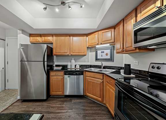 A modern kitchen with wooden cabinets and stainless steel appliances.