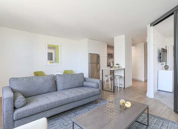 A grey couch with a yellow pillow sits in a living room.