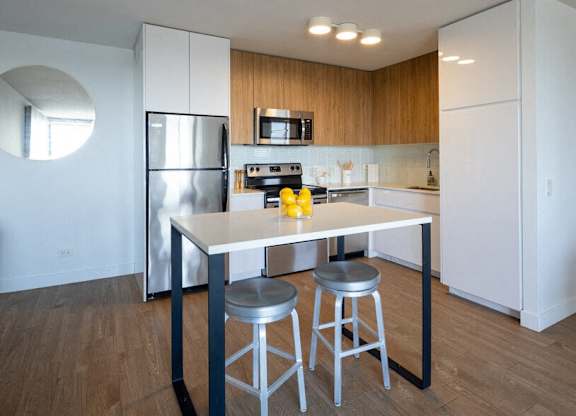 A kitchen with a table and two stools.