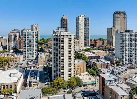 A cityscape with a mix of modern and older buildings, with a clear blue sky above.