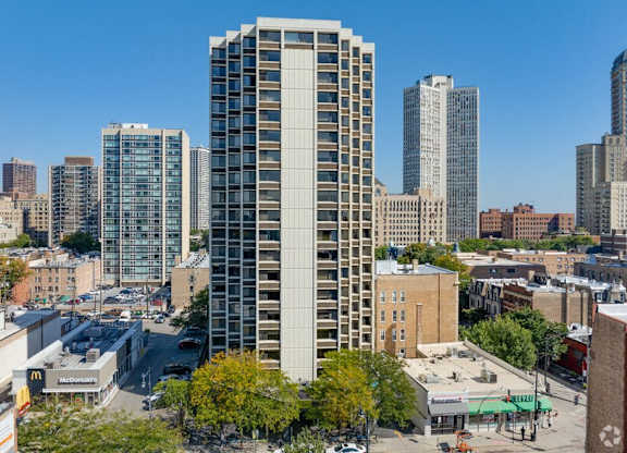 A tall building stands in the middle of a city street.
