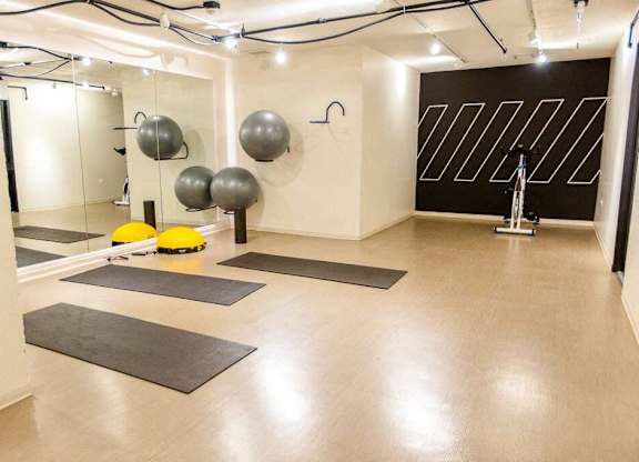 A yoga studio with a mirror, exercise balls, and yoga mats.