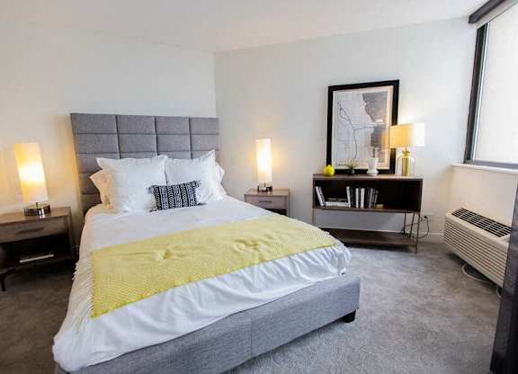 A bedroom with a large bed and a grey headboard.