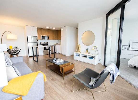 A modern living room with a grey sofa and a yellow throw.