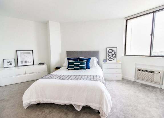 A bedroom with a large bed and a window.