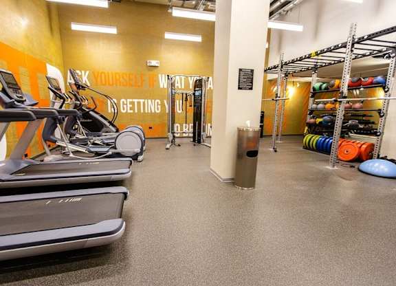 A gym with treadmills and a motivational quote on the wall.