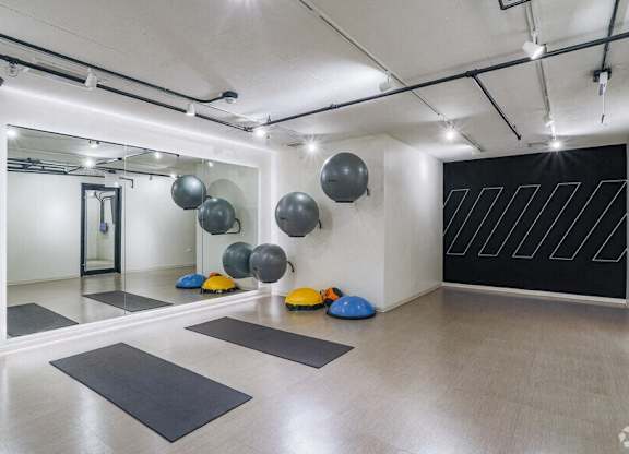 A yoga studio with a black and white wall and a mirror on the wall.