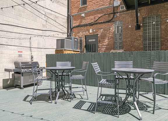 A patio with a table and chairs is set up on a brick patio.