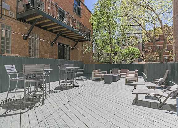 A wooden deck with chairs and a table.