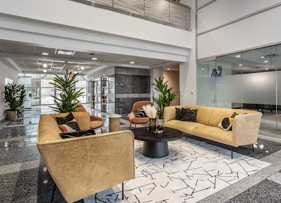 A contemporary living space at Altura Apartments furnished with a vibrant yellow sofa and a low coffee table.