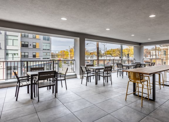 An outdoor sky lounge with tables, chairs, and a couch at Madamore.