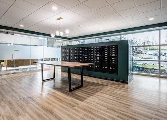 A meeting or dining room with a long table and a black presentation panel mounted on the wall.