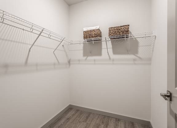 A bright white room fitted with a wire shelving unit holding two storage baskets.