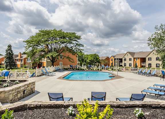 Fairway Lakes swimming pool surrounded by trees and lounge chairs,