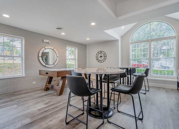 A dining room with a round table and chairs.