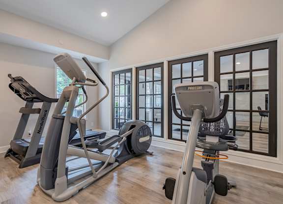 A home gym with a treadmill, elliptical trainer and a stationary bike.