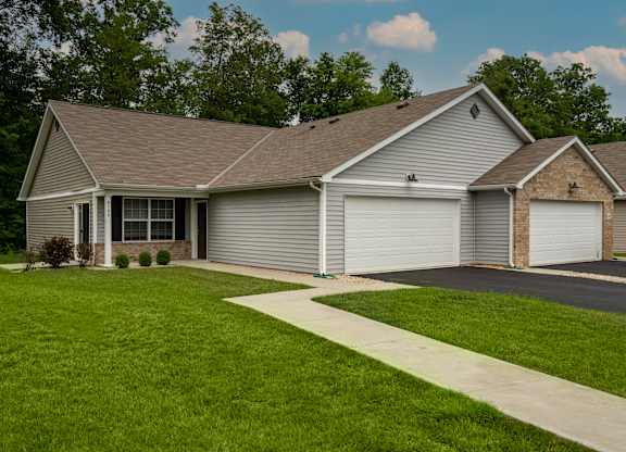 A house with a grey roof and two garages.
