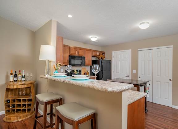 A kitchen with a bar area and a wine rack.