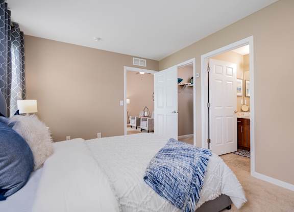 A bedroom with a bed and a nightstand with a lamp.