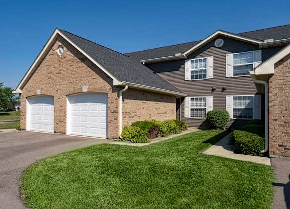 A house with a grey roof and a white garage door.