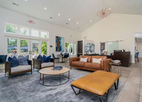 A living room with a brown leather sofa and a round coffee table.