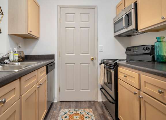 A kitchen with a white door in the middle of the room.