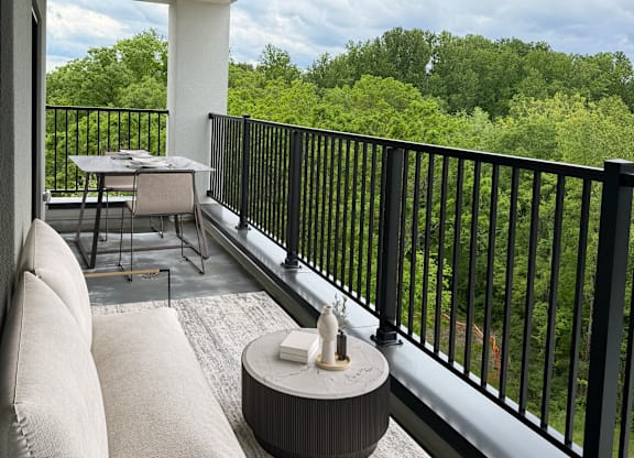 Altura balcony with a table and chairs overlooking a green landscape