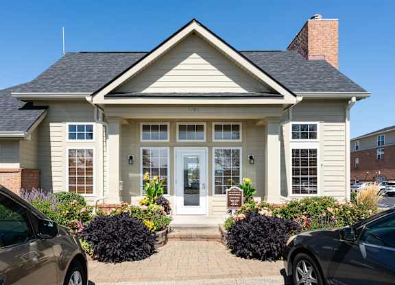Residential home with parked cars in the driveway