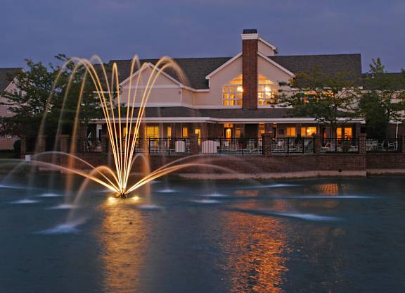 Exterior view of Britton Woods Apartments with pet-friendly walking paths and a pond with a fountain