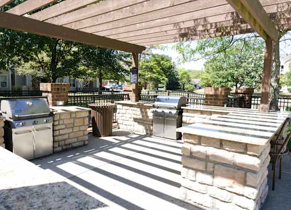 Outdoor patio area with BBQ grills and a shaded awning for community gatherings