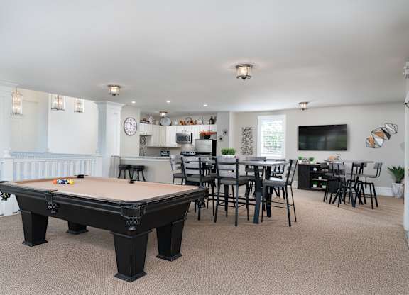 Game room with a pool table, lounge chairs, and a TV entertainment setup